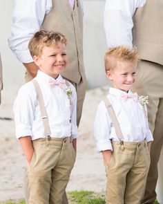 two young boys wearing suspenders and bow ties standing next to each other with their parents