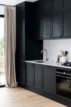 a kitchen with black cabinets and white counter tops