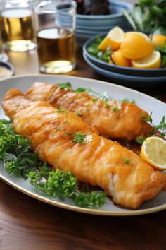 two fish fillets on a plate with lemons and parsley