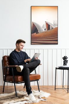 a man sitting in a chair using a laptop computer