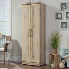 a wooden cabinet sitting in the corner of a room next to a chair and potted plant