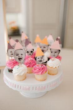 cupcakes with faces on them sitting on a cake plate