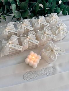 wedding favors with pearls and bows on a table