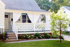 a house with white curtains on the front porch