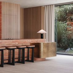 a modern kitchen with marble counter tops and bar stools in front of the window