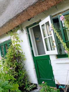 a white house with green doors and windows