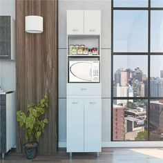 a white microwave oven sitting inside of a kitchen next to a potted green plant