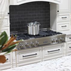 a stove top oven sitting in a kitchen next to a vase with flowers on it