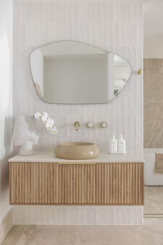 a bathroom with a sink, mirror and toiletries on the counter in front of it