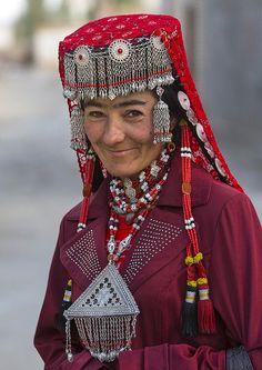 Tajik woman in Tashkurgan, Xinjiang, China  by Eric Lafforgue on Flickr            (Larger), then click again    The photographer says: “Most of the ones I met wore  some beautiful hats and necklaces. I asked why she had  those decorations, she answered it was her daily clothes! Eric Lafforgue, We Are The World, Cultural Diversity, Beautiful Hats