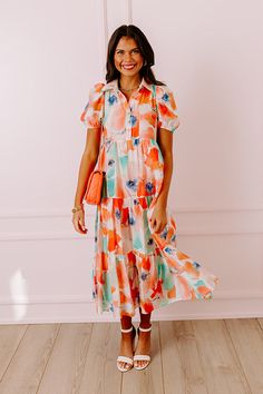 - Let your delicate feminine side show with this gorgeous floral dress! - Fully lined material with an abstract floral watercolor print - A collared neckline - A button down bodice - Short puff sleeves - A flowy yet flattering silhouette that ends in a midi length hemline Spring Collared Midi Dress With Floral Print, Flowy Orange Floral Print Midi Dress, V-neck Midi Dress With Vibrant Print For Beach, Floral Print Button-up Midi Dress For The Beach, Orange A-line Midi Dress With Floral Print, Printed Viscose Midi-length Dress, Tropical Multicolor Midi-length Maxi Dress, Abstract Floral, Midi Length