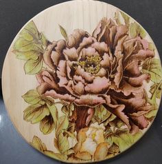 a wooden plate with flowers painted on it