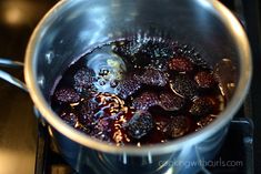 berries are being cooked in a saucepan on the stove top, ready to be eaten