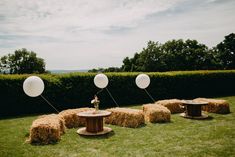 some hay bales and balloons in the grass