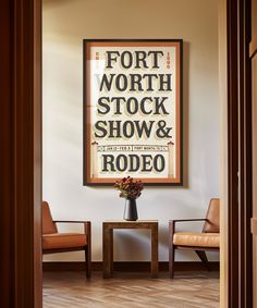 a room with two chairs and a sign on the wall above it that says fort worth stock show & rodeo