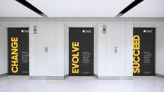 three black and white doors with yellow lettering on them in an empty room that says change