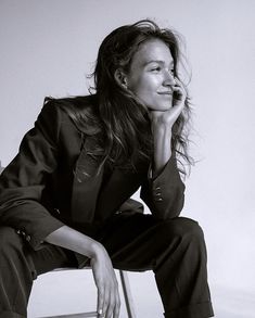 a black and white photo of a woman sitting on a chair