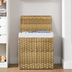 a wicker laundry hamper sitting on top of a wooden floor next to a white wall