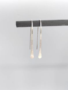 Matte satin finish, long drop recycled Sterling silver earrings,  hand-forged from a length of solid silver eco wire. The satin finish gives them a very modern look. They are made using a traditional method called planishing which flattens and smooths out the silver, before the Satin finish. This process also hardens the silver, making them tough but also lightweight and comfortable to wear. 4 or 5 cm long Silver width 0.9mm (US 19 Gauge) Each pair of earrings are handmade in the UK using tradit Silver Linear Earrings With French Hook Gift, Handmade Sterling Silver Threader Earrings For Everyday, Handmade Minimalist Long Drop Linear Earrings, Simple Silver Threader Earrings As Gift, Minimalist Hammered Drop Earrings, Silver Long Drop Hand Forged Earrings, Nickel-free Sterling Silver Teardrop Threader Earrings, Minimalist Silver Long Drop Threader Earrings, Handmade Sterling Silver Long Drop Threader Earrings