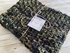 a green and brown crocheted dishcloth with a white tag attached to it