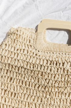 Our Oversized Straw Tote has a woven detail, natural wood handles, a top zipper closure, exterior side snaps, and an inside small open sidewall pocket. Exterior: 100% Straw Interior: 30% Cotton/70% Polyester Measurements: 17.5" x 15" Spring Vacation Cotton Straw Bag, Spring Natural Straw Cotton Bag, Spring Natural Cotton Straw Bag, Casual Spring Cotton Straw Bag, Corset And Skirt, Bolero Top, Gift Card Boxes, Wood Handles, Tiered Maxi Skirt