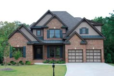 a large brick house with two garages on the front and one story above it