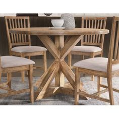 a wooden table with chairs around it and a vase on the table top in front of it