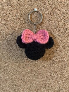 a crocheted mickey mouse keychain with a pink and black bow on it