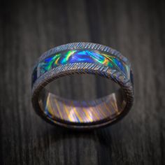 This Kuro-Ti ring Features:- 8mm Width- Flat Shape- Anodized/Etched Finish- 4mm Dichrolam Inlay (Black Sea Burl Shown) Celtic Patterns, Wave Ring, Pattern Ring, Flat Shapes, Silicone Rings, Custom Ring Designs, Black Sea, Men's Ring, Damascus Steel