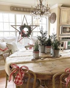 a dining room table with potted plants on it and a star hanging from the ceiling