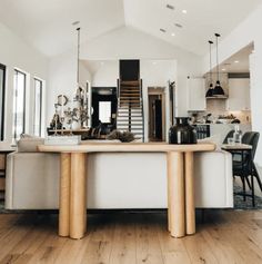 a living room and dining area with wood flooring in the middle, white walls and ceiling