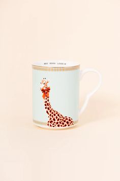 a mug with a giraffe painted on the front and sides, sitting against a white background