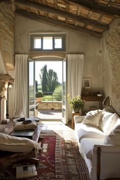 a living room filled with furniture and a fire place in front of a door that leads to an outside patio