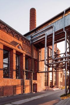 an old brick building with metal pipes and windows