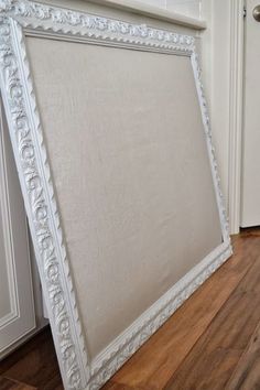 a white frame sitting on top of a hard wood floor