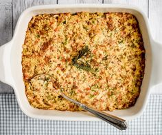 a casserole dish with meat and vegetables in it on a checkered tablecloth