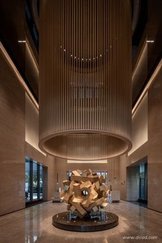 an artistic sculpture in the middle of a large room with high ceilings and wooden slats hanging from the ceiling