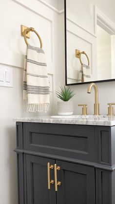 a bathroom with a sink, mirror and towel hanging on the wall next to it