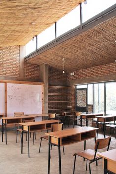 an empty classroom with wooden desks and chairs