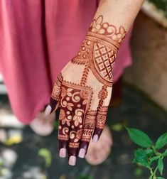 a woman's hand with henna tattoos on it