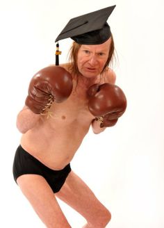 an old man wearing boxing gloves and a graduation cap is posing for the camera with his hands on his hips