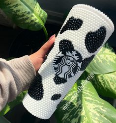 a hand holding a starbucks cup case with black and white polka dots on the bottom