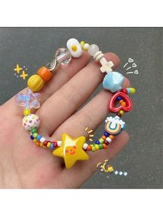 a person's hand holding several different types of beads and rings on their fingers