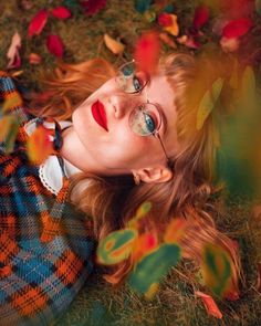 a woman laying on the ground wearing glasses