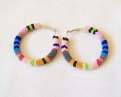 "These beaded colorful crochet hoop earrings are made using 12 colors Czech seed beads. Hoops are approximately 2\" in diameter. You can find matching Beaded Crochet Rope Necklace - Lariat in my shop: https://www.etsy.com/listing/198965374/long-beaded-crochet-rope-necklace To browse more of my Earrings please follow the link: http://www.etsy.com/shop/lutita?section_id=11451910 Return to the Lutita Shop: www.etsy.com/shop/lutita" Handmade Colorful Beaded Round Earrings, Multicolor Tiny Beads Hoop Earrings As A Gift, Multicolor Hoop Earrings With Tiny Beads As Gift, Multicolor Beaded Hoop Earrings For Gift, Multicolor Tiny Beads Small Hoop Earrings, Multicolor Hoop Earrings With Large Beads As Gift, Handmade Colorful Beaded Hoop Earrings, Handmade Rainbow Beaded Round Earrings, Multicolor Round Beaded Earrings