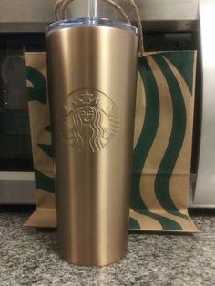 a starbucks cup sitting on top of a counter next to a bag