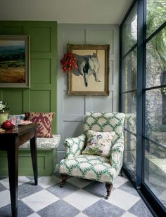 a chair sitting in front of a window next to a table