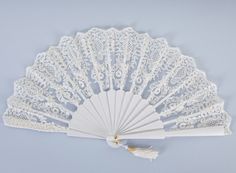 a white lace fan with tassels on it