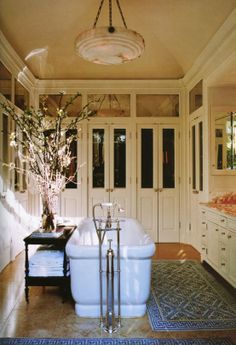 a bathroom with a claw foot tub and chandelier hanging from it's ceiling