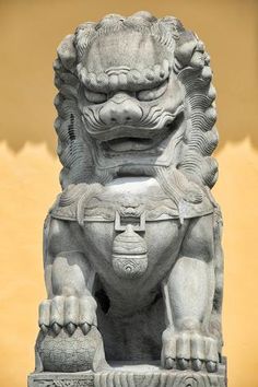 a stone lion statue sitting in front of a building